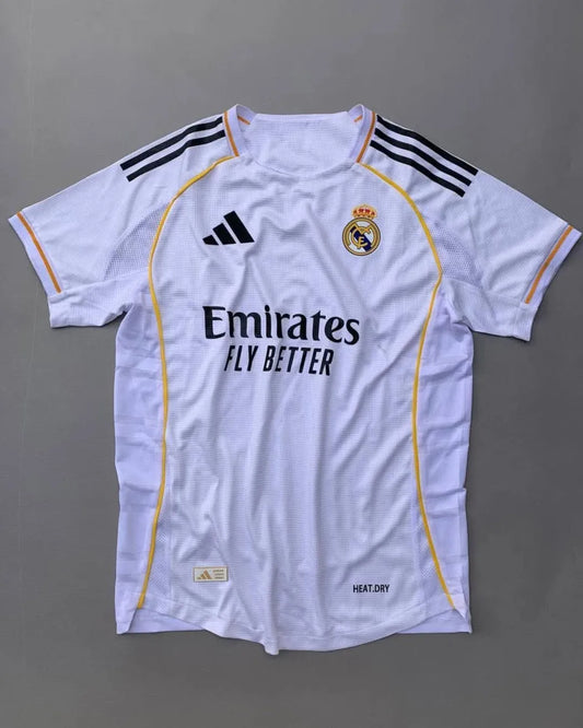 Real Madrid 2025/26 home jersey with classic white design, black adidas stripes, golden-yellow trim, Emirates Fly Better sponsor, and embroidered club crest – official fan and player kit